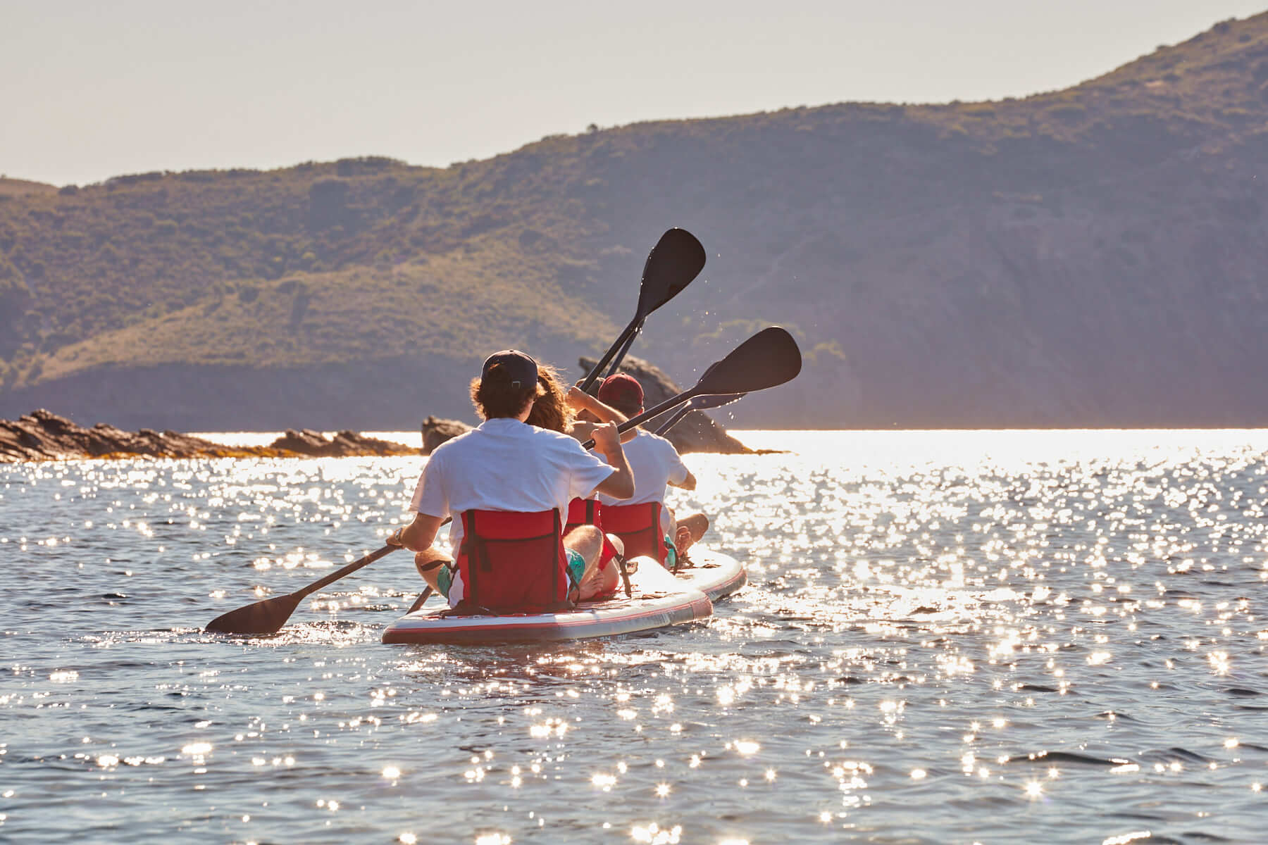 Redsharkbike kayak surf board sur l'eau montrant un groupe de personnes en train de ramer.